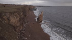 Drone flies up and away rock stack on Chemical Beach, Seaham on a stormy winter day