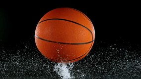 Super slow motion of falling basketball ball on water surface, black background. Filmed on high speed cinematic camera at 1000 fps. - Powered by Shutterstock - Get 15% off with code: PIKWIZARD15