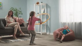 young woman, mother with children playing in room, throwing toys, twisting hoop, weekend with children, family - Powered by Shutterstock - Get 15% off with code: PIKWIZARD15