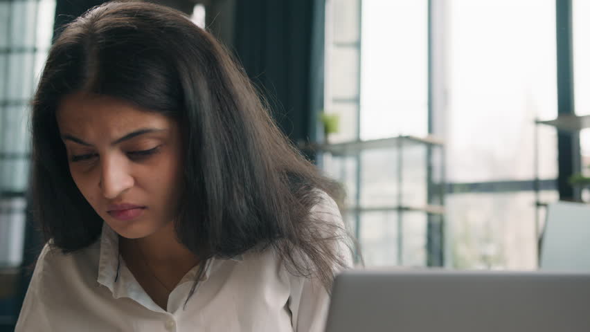 Indian anxious woman with computer working business problem in office Arabian dissatisfied girl worker upset confused businesswoman work with laptop online mistake trouble bad results job difficulties Royalty-Free Stock Footage #1103658783