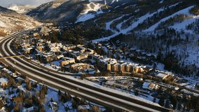 Aerial Cinematic Drone i70 cars on highway at Vail Village Vail ski resort late afternoon sunset of ski trails and gondola scenic mountain landscape of Colorado forward pan up reveal movement - Powered by Shutterstock - Get 15% off with code: PIKWIZARD15