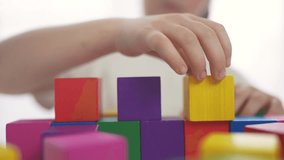 child girl in kindergarten play with blocks on table by the window. education fun development children game concept. child kid play with blocks at home rejoice having. child play cube at home - Powered by Shutterstock - Get 15% off with code: PIKWIZARD15