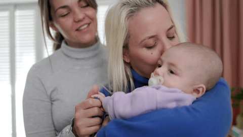 Gay lesbian couple mothers and newborn baby enjoying together at home - Lgbt family concept Stock Video