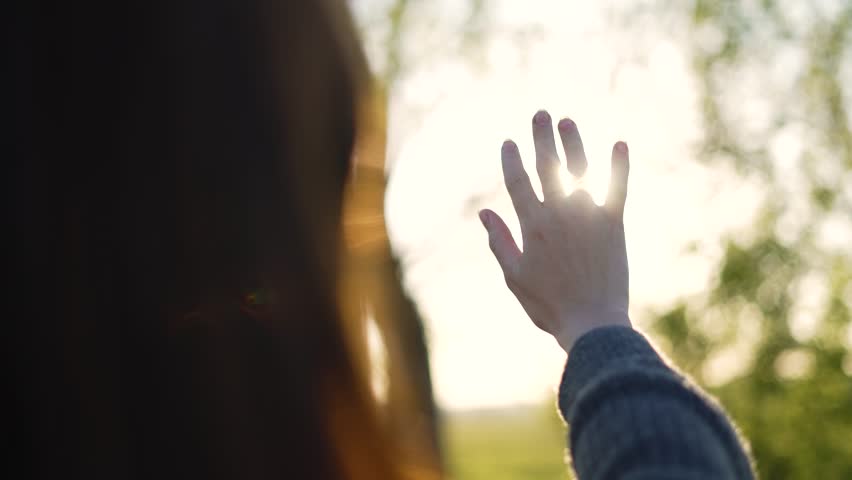 Hand of happy girl at sunset. Sunset between the hands of girl. Happy girl with long hair dreamily stretches out her hand to sun. Child's dream hand to the sun. happy family concept. Freedom in nature Royalty-Free Stock Footage #1103664131