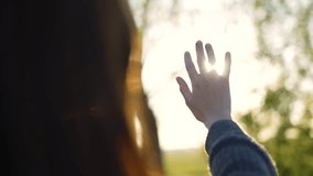 Hand of happy girl at sunset. Sunset between the hands of girl. Happy girl with long hair dreamily stretches out her hand to sun. Child's dream hand to the sun. happy family concept. Freedom in nature - Powered by Shutterstock - Get 15% off with code: PIKWIZARD15