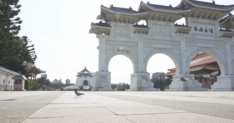 Slow motion of of CKS (Chiang Kai Shek) Memorial Hall with pigeons fly in Tapiei, Taiwan. The meaning of the Chinese text on the archway is "Liberty Square"