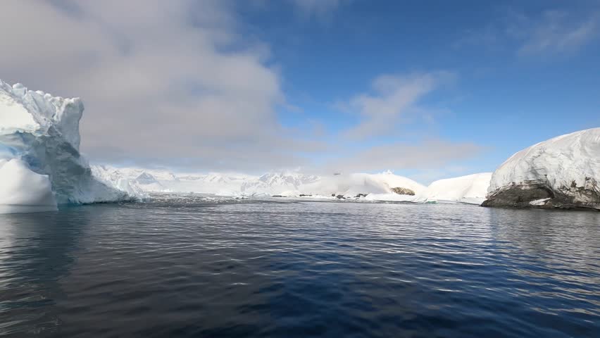 Giant floating Iceberg from melting glacier in Antarctica. View and 4K shooting from a yacht. Nature landscape famous for being heavily affected by global warming. Global Warming and Climate Change.