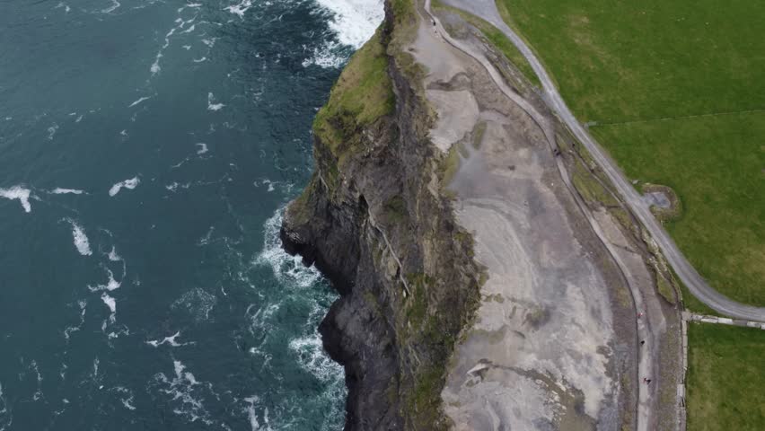 The Cliffs of Moher are sea cliffs located at the southwestern edge of the Burren region in County Clare, Ireland. They run for about 14 kilometres Royalty-Free Stock Footage #1103668211