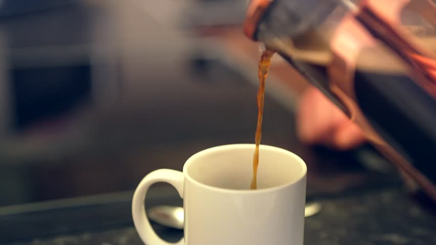 Steaming hot coffee is poured from glass carafe into bright white cup Royalty-Free Stock Footage #1103668545