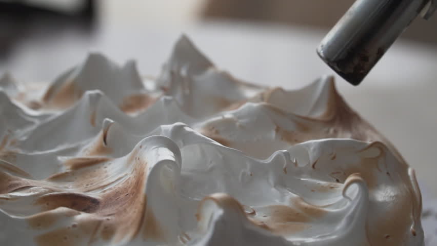 close up on tip of pastry torch roasting meringue pie topping, natural light, slow motion Royalty-Free Stock Footage #1103670063