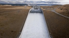 Water running down ramp at hydro electricity facility near glacial lake in new Zealand; aerial approach