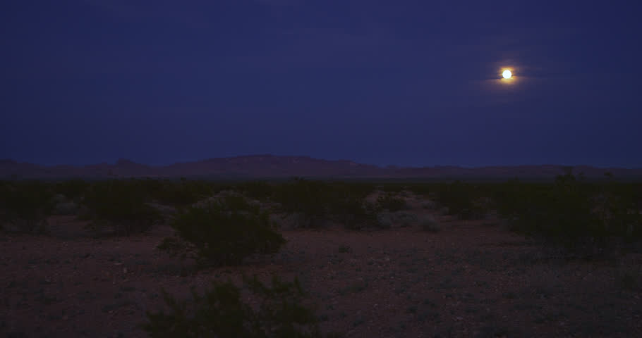 Desert moonrise at the cusp of darkness during the evening’s blue-hour.