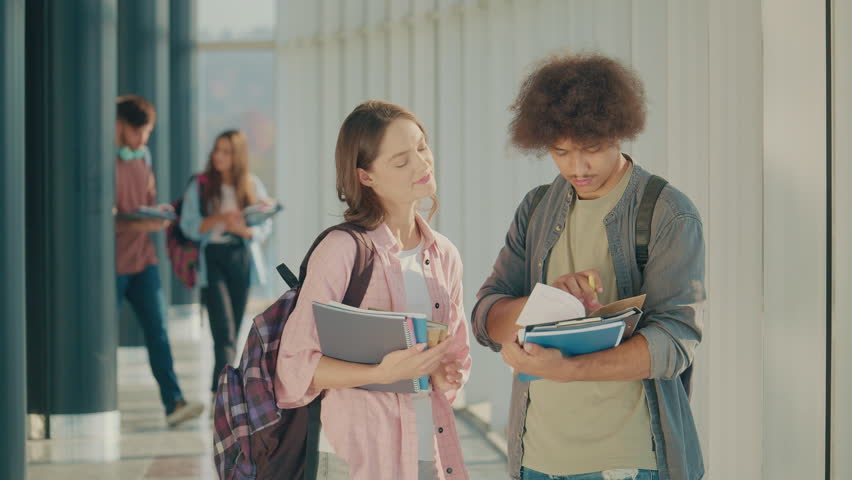 Two Attractive Students Talk at High School College Hall. Young Leaders. Cultural Diversity in Education and Society - Powered by Shutterstock - Get 15% off with code: PIKWIZARD15
