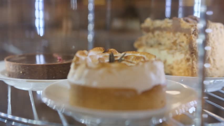 cakes and cupcakes in the window behind the glass slowly rotate