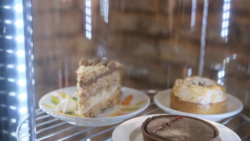 cakes and cupcakes in the window behind the glass slowly rotate