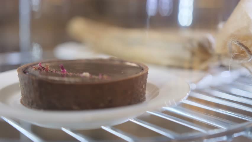 cakes and cupcakes in the window behind the glass slowly rotate