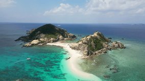 Okinawa, Japan: Aerial drone footage of a boat carrying tourist to islands off the Aharen Beach in Tokashiki, part of the Kerama islands off Naha in Okinawa in the Pacific ocean in Japan. 