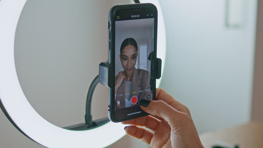 Beauty blogger started recording video mobile phone view at apartment. Closeup woman greeting subscribers talking to cellphone camera. Happy influencer girl creating content broadcasting live stream