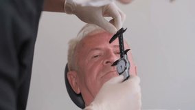 Portrait of doctor surgeon making marks on male face, elderly man. 4k video