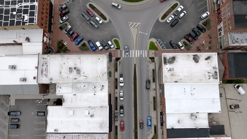 Angola, Indiana town square roundabout with cars moving around and drone video looking down and moving forward.