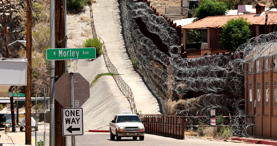 Daytime view of the fortified USA Mexico border wall as it runs through downtown Nogales, Arizona, USA.