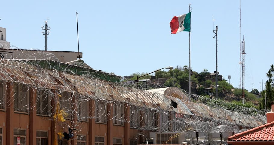 Daytime view of the fortified USA Mexico border wall as it runs through downtown Nogales, Arizona, USA.