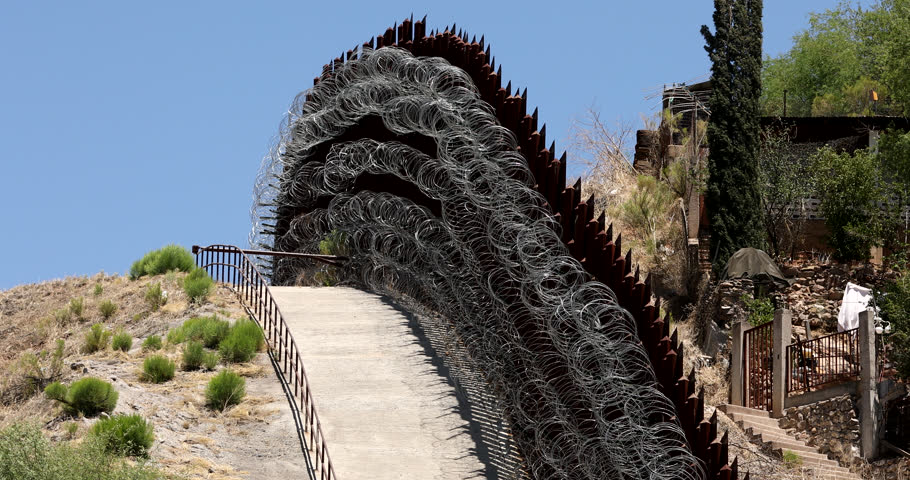 Daytime view of the fortified USA Mexico border wall as it runs through downtown Nogales, Arizona, USA.