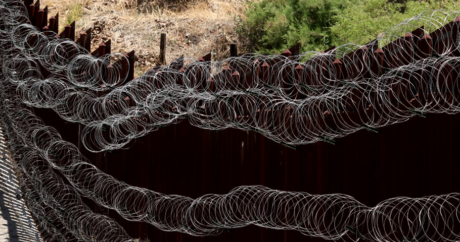 Daytime view of the fortified USA Mexico border wall as it runs through downtown Nogales, Arizona, USA.