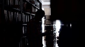 Silhouette of student man reading book in the library, side view, contrast light. Young man in university library near bookshelves reading book - Powered by Shutterstock - Get 15% off with code: PIKWIZARD15
