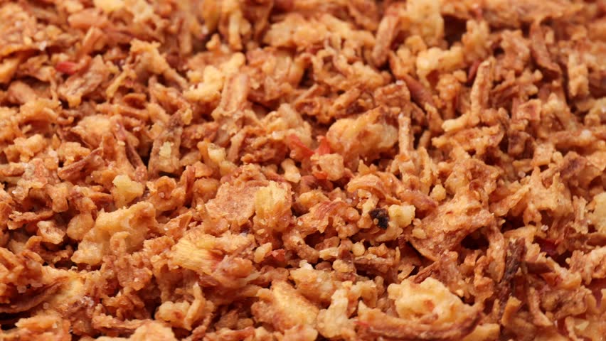 crispy onions , rotation in circle. Traditional fried crispy onions backed in flour , Turning. selective focus. yellow background, fast food