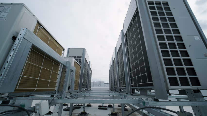 The air conditioning and ventilation system of a large industrial facility is located on the roof. It includes an air conditioner, smoke exhaust, and ventilation. Royalty-Free Stock Footage #1103735183
