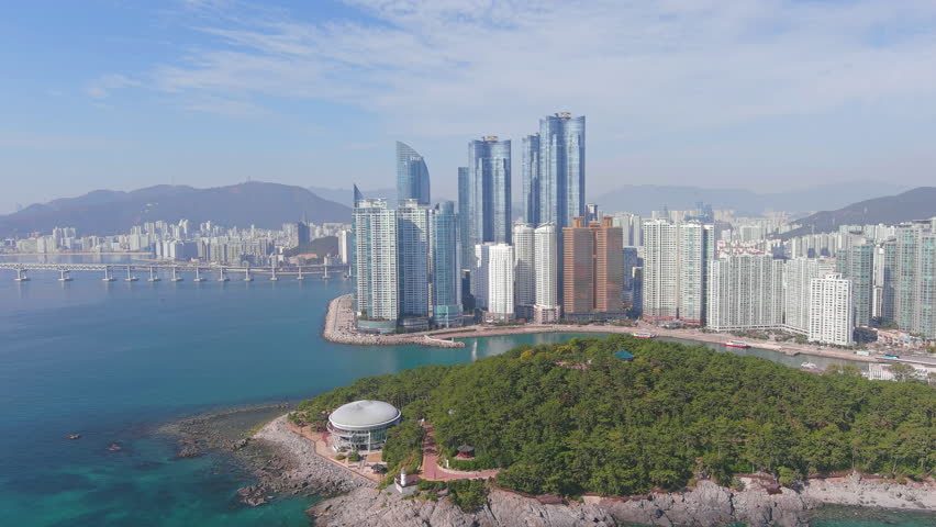 BUSAN, SOUTH KOREA - CIRCA 2021: Aerial view of city in South Korea, skyline with modern high-rise buildings (skyscrapers) and Haeundae Beach, sunny day with blue sky - landscape panorama of Eastern A