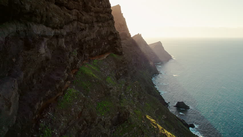 Majestic volcanic mountains and Atlantic ocean landscape on Gran Canaria, Canary Islands, Spain. Mirador El Balcon viewpoint on Gran Canaria Island. Aerial view of rocky coast at sunset