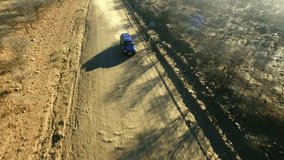 Tearing way at the desert road. 4k video drone footage of a truck driving along a dirt road through the Namibian desert.