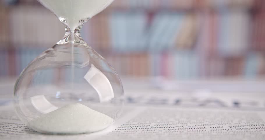 Hourglass or sandglass : Closeup of white sand falling down through a narrow neck in a sand clock or sand timer. Indicating passing of time. Each hourglass measures and has specific duration of time. Royalty-Free Stock Footage #1103763189