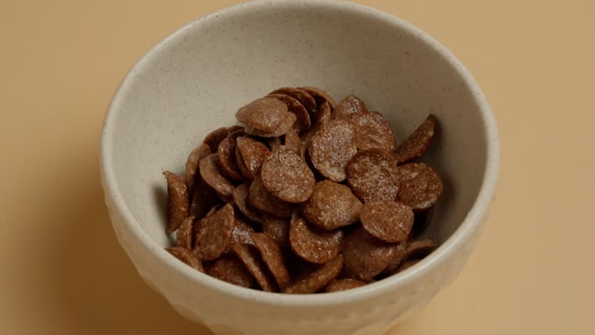 pouring milk on cereal in a bowl and splashing -breakfast - colorful background (4k - slow motion)[ high quality colors]