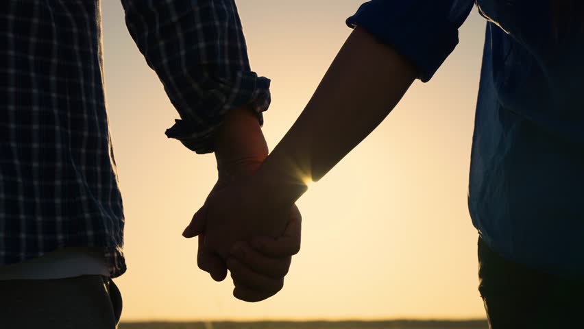 Closeup of guy lets go of girls hand, separation. Separation of hands of man of woman. Family at sunset. Pair of man, woman separate their hands in front of sun. Separation, separation, quarrel. Royalty-Free Stock Footage #1103770449