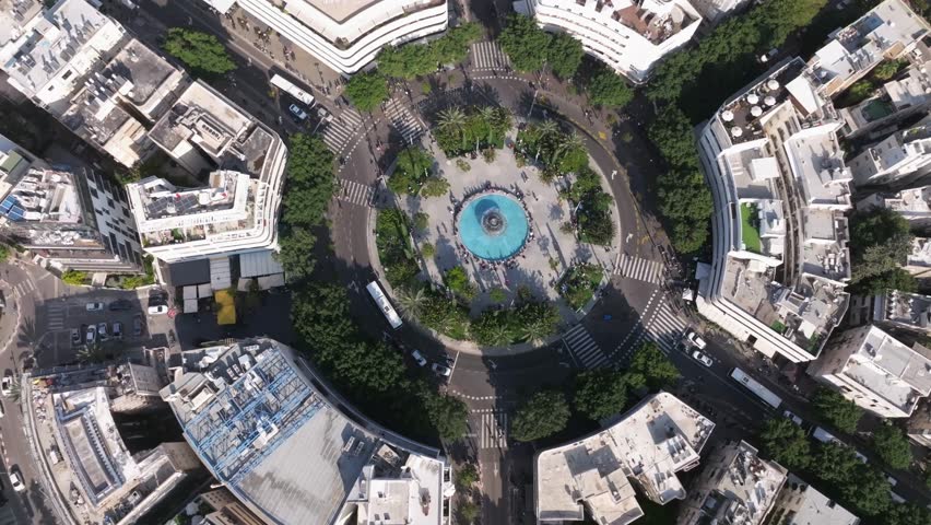 Tel Aviv , Israel ,Dizengoff square full of people on a sunny summer day , dynamic Aerial view of the square, fountain and surrounding buildings . Urban city lively public meeting place Royalty-Free Stock Footage #1103777157