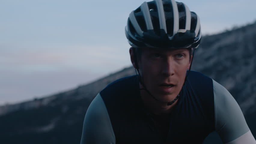 Professional athlete rides road bike on steep mountain road. Portrait of road endurance cyclist during hard training or competition race | Shutterstock HD Video #1103778199