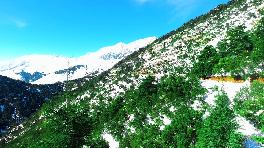 Aerial view of a mountain range in Tikejda Algeria, with the snow mountain under the blue sky