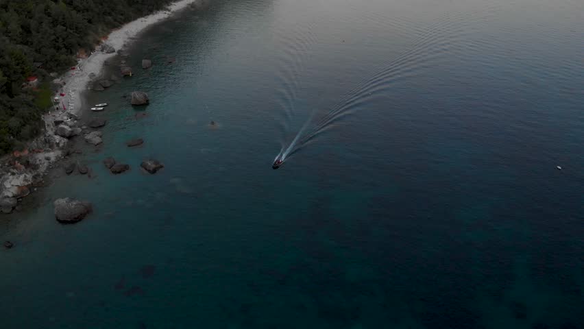Water Taxi Cruising On The Adriatic Sea At Jaz Beach In Budva, Montenegro At Dusk. aerial