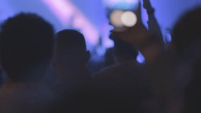 People enjoy a live concert in blue lighting