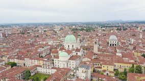 Inscription on video. Brescia, Italy. Cathedral of Santa Maria Assunta. Flight over the city in cloudy weather. Shimmers in colors purple, Aerial View, Point of interest