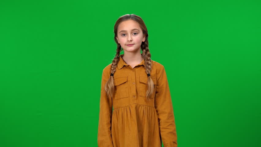 Bored Caucasian teenage girl looking at camera and yawning looking away standing at green screen. Front view portrait of disinterested tired teenager posing at chroma key Royalty-Free Stock Footage #1103799519