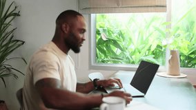 Young business black african american man working from home on table with notebook computer laptop
