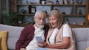 Mature happy couple use smartphone. A gray-haired husband and wife read the news on the phone. . Happy pensioners. Older grandparent learn using modern technology gadget concept. - Powered by Shutterstock - Get 15% off with code: PIKWIZARD15
