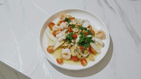 4k video, Spicy Shrimp Salad in White Plate on Set,The Famous Menu of Thai Food in Thailand. Spicy fruit salad with shrimp and mushroom - Asian food style
