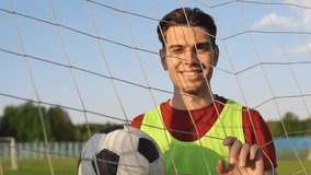 Portrait of a happy male football player with a soccer ball near net in slow motion - Powered by Shutterstock - Get 15% off with code: PIKWIZARD15