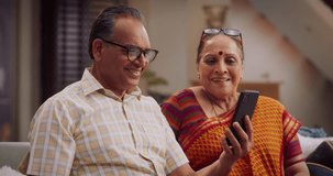 Amazing Elderly Indian Couple Using Smartphone for Video Call at Home. Beautiful Hindu Granparents Waving and Greeting Grandchildren, Talking with Relatives and Friends. Medium Close-up Slow Motion