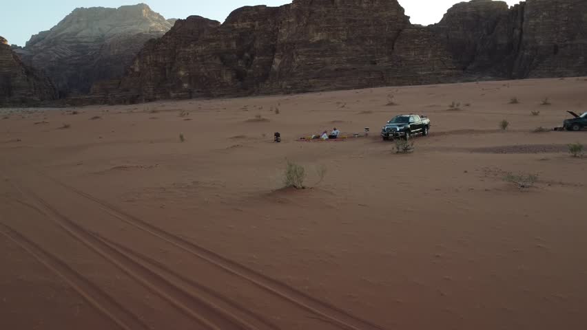 Jordan Aerial shot from above with group of people driving in off road vehicle in the middle of the Wadi Rum desert, Jordan